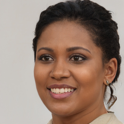 Joyful black young-adult female with short  brown hair and brown eyes