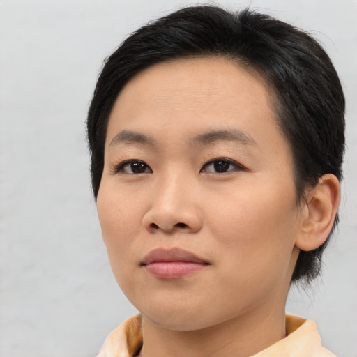 Joyful asian young-adult female with short  brown hair and brown eyes