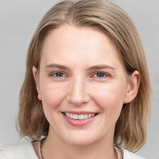 Joyful white young-adult female with medium  brown hair and blue eyes