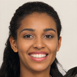 Joyful black young-adult female with long  brown hair and brown eyes