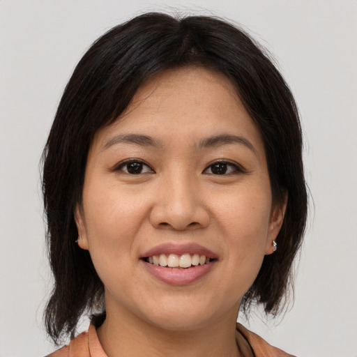 Joyful asian young-adult female with medium  brown hair and brown eyes
