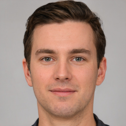 Joyful white young-adult male with short  brown hair and grey eyes