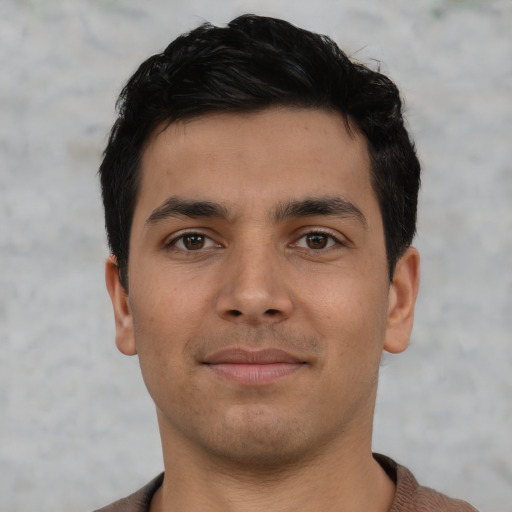 Joyful latino young-adult male with short  brown hair and brown eyes