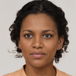 Joyful black young-adult female with medium  brown hair and brown eyes