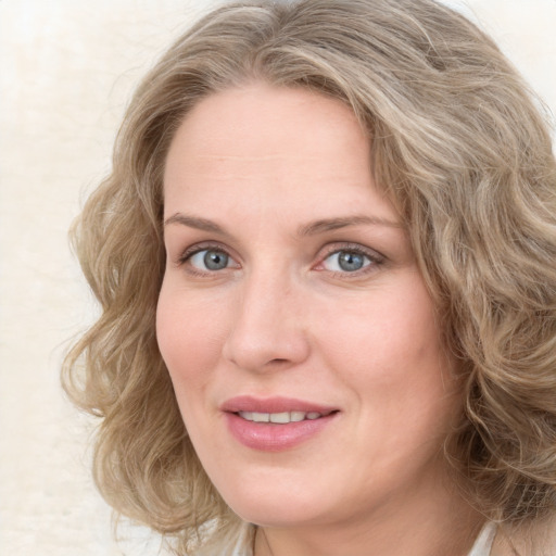 Joyful white adult female with medium  brown hair and blue eyes