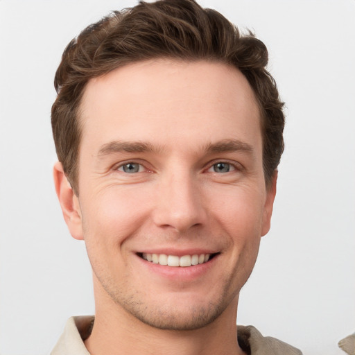 Joyful white young-adult male with short  brown hair and grey eyes