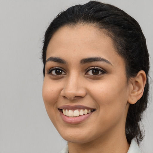 Joyful latino young-adult female with long  brown hair and brown eyes