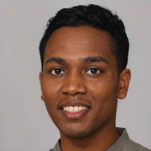 Joyful black young-adult male with short  black hair and brown eyes