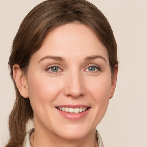 Joyful white young-adult female with medium  brown hair and grey eyes