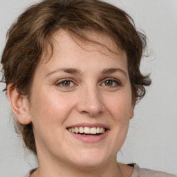 Joyful white young-adult female with medium  brown hair and green eyes