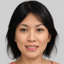 Joyful asian young-adult female with medium  brown hair and brown eyes