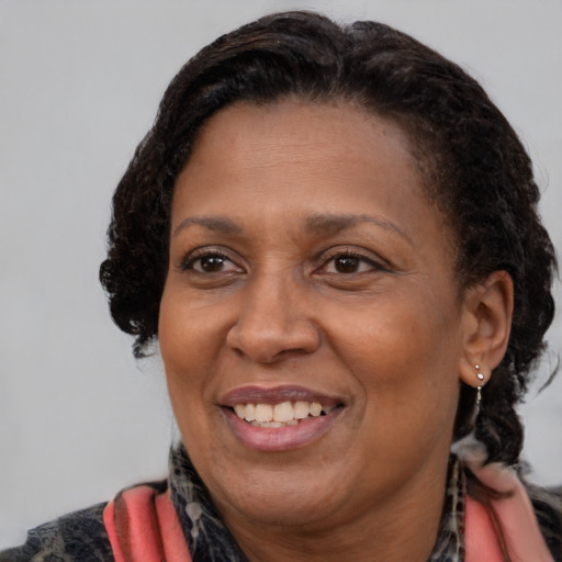 Joyful black adult female with medium  brown hair and brown eyes