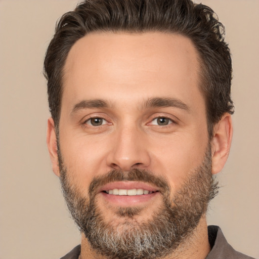 Joyful white adult male with short  brown hair and brown eyes