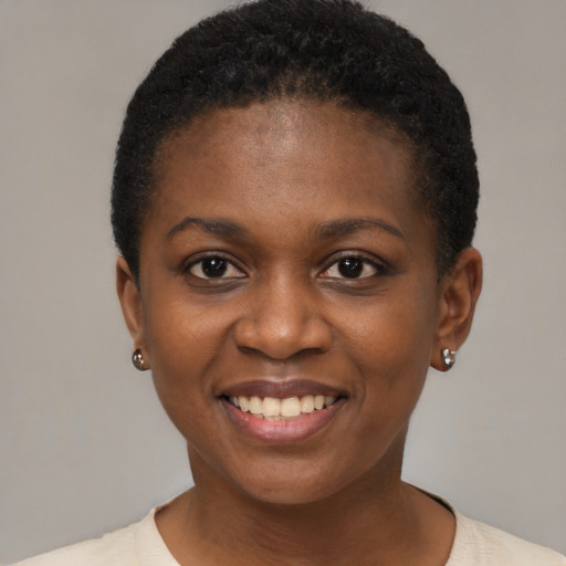 Joyful black young-adult female with short  black hair and brown eyes
