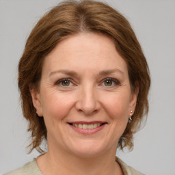 Joyful white adult female with medium  brown hair and grey eyes