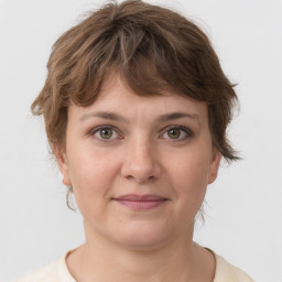 Joyful white young-adult female with medium  brown hair and green eyes