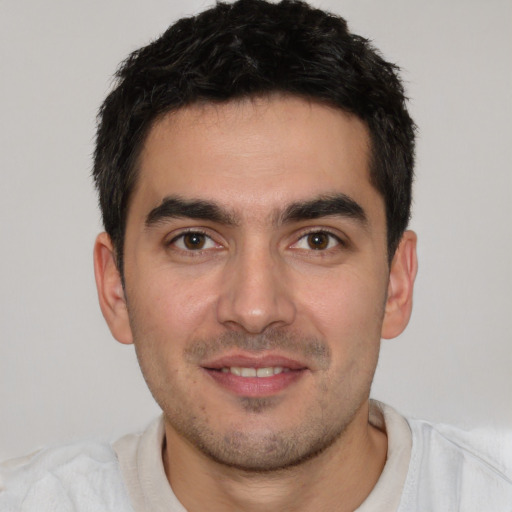 Joyful white young-adult male with short  black hair and brown eyes