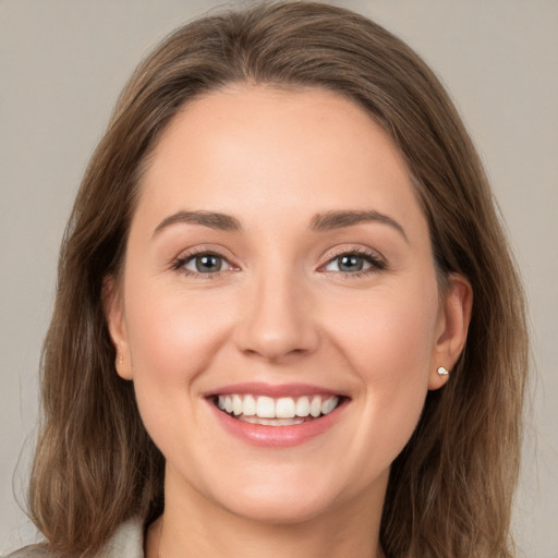 Joyful white young-adult female with long  brown hair and grey eyes