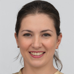 Joyful white young-adult female with medium  brown hair and grey eyes