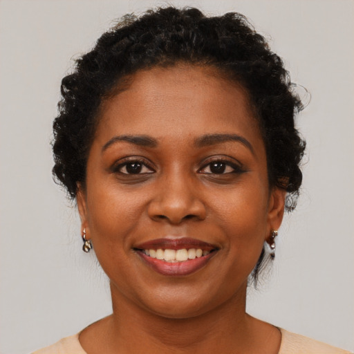 Joyful black young-adult female with short  brown hair and brown eyes