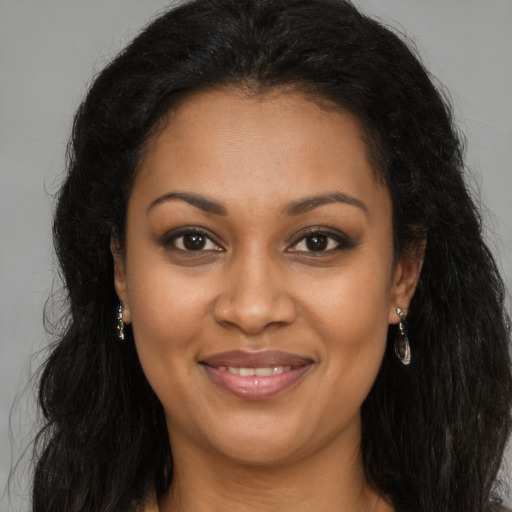 Joyful black young-adult female with long  brown hair and brown eyes