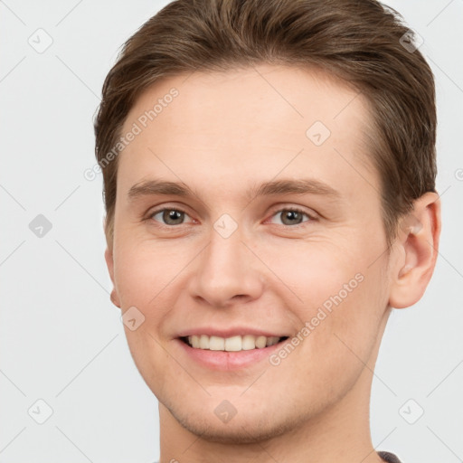 Joyful white young-adult male with short  brown hair and grey eyes