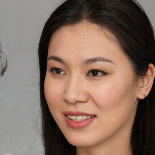 Joyful asian young-adult female with long  brown hair and brown eyes