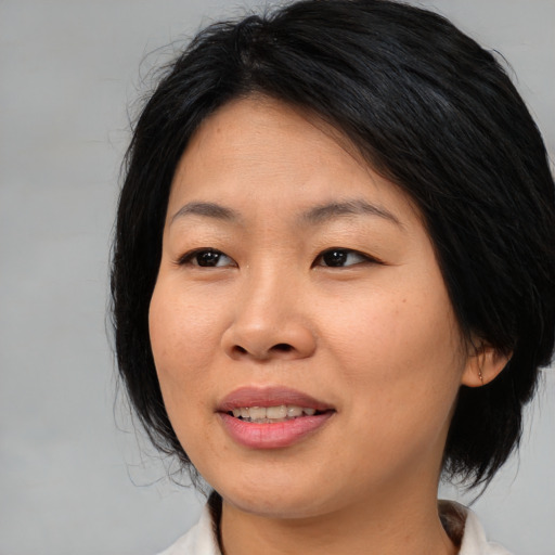 Joyful asian young-adult female with medium  brown hair and brown eyes