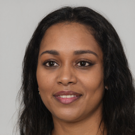 Joyful black young-adult female with long  black hair and brown eyes