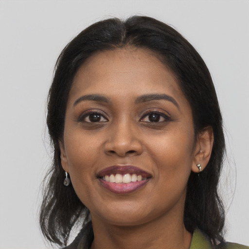 Joyful black young-adult female with long  black hair and brown eyes