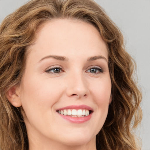 Joyful white young-adult female with long  brown hair and green eyes