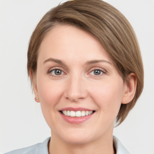 Joyful white young-adult female with medium  brown hair and grey eyes