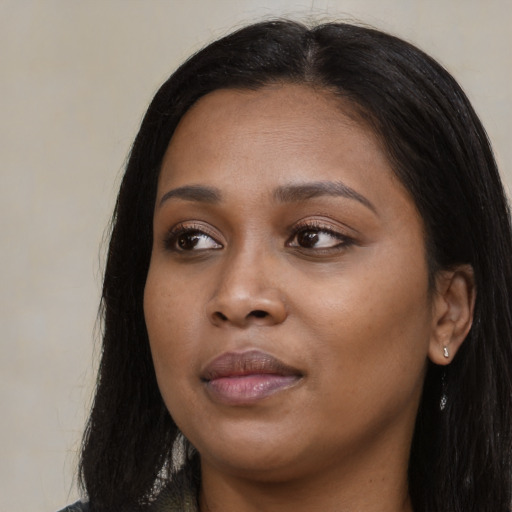 Joyful black young-adult female with long  black hair and brown eyes