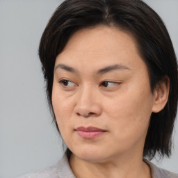 Joyful asian adult female with medium  brown hair and brown eyes