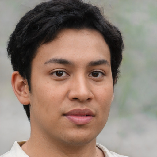 Joyful latino young-adult male with short  brown hair and brown eyes
