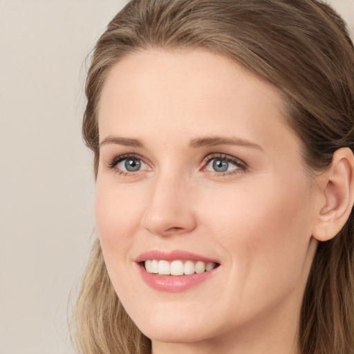 Joyful white young-adult female with long  brown hair and grey eyes