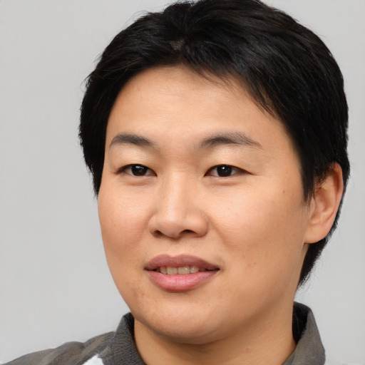 Joyful asian young-adult female with short  black hair and brown eyes