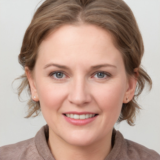 Joyful white young-adult female with medium  brown hair and blue eyes