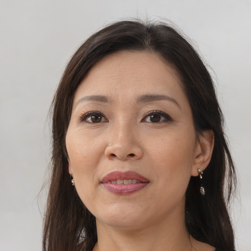 Joyful asian adult female with long  brown hair and brown eyes