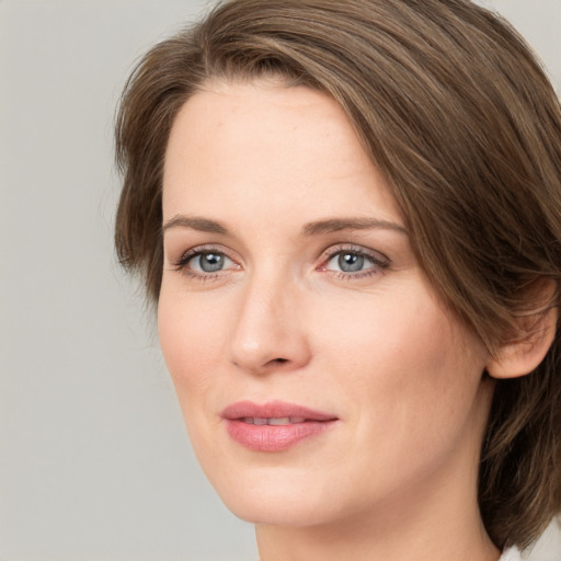 Joyful white young-adult female with medium  brown hair and green eyes