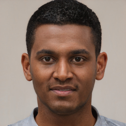 Joyful black young-adult male with short  black hair and brown eyes