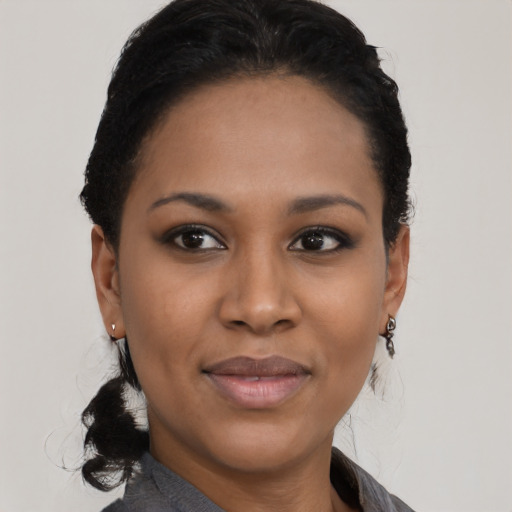 Joyful black young-adult female with short  black hair and brown eyes