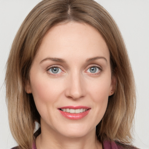 Joyful white young-adult female with medium  brown hair and blue eyes