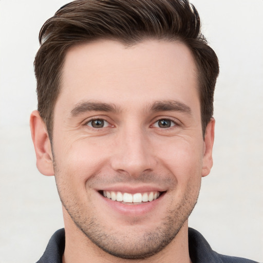 Joyful white young-adult male with short  brown hair and grey eyes