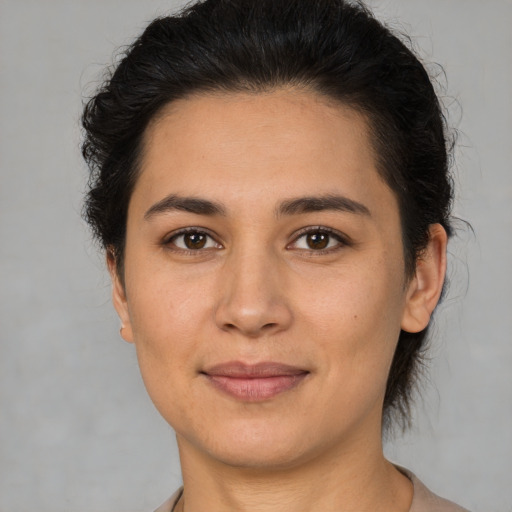 Joyful latino young-adult female with medium  brown hair and brown eyes