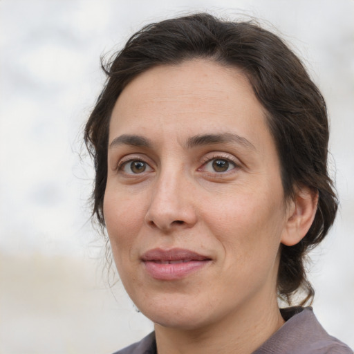 Joyful white adult female with medium  brown hair and brown eyes