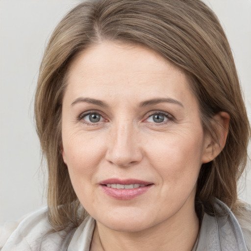 Joyful white adult female with medium  brown hair and grey eyes