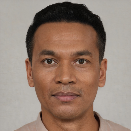 Joyful black young-adult male with short  black hair and brown eyes
