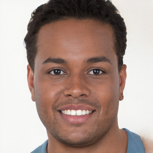 Joyful black young-adult male with short  brown hair and brown eyes