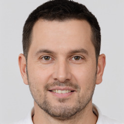 Joyful white young-adult male with short  brown hair and brown eyes